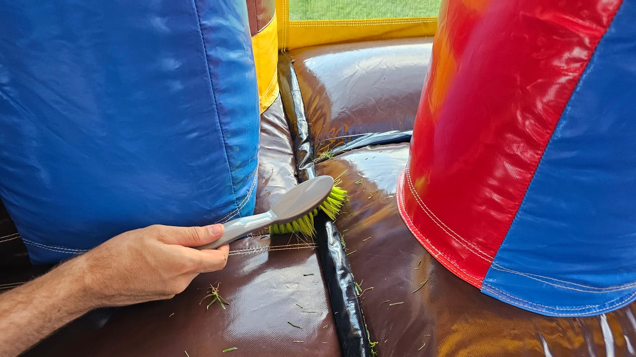 Hüpfburg wird mit dem Handbesen gereinigt